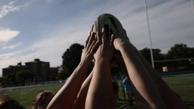 Group of female rugby players raising a rugby ball together, symbolizing teamwork and unity on the field. Female Rugby Players Raising Ball in Unity0 - Powered by Shutterstock - Get 15% off with code: PIKWIZARD15