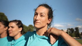 Determined female rugby players in blue jerseys huddling with focused expressions before a game. Focused Female Rugby Players in a Huddle - Powered by Shutterstock - Get 15% off with code: PIKWIZARD15