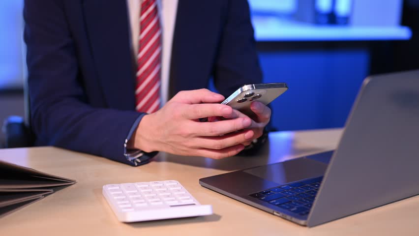 Businessman  counting coins on calculator taking from the piggy bank. hand holding pen working on calculator to calculate on desk about cost at home office.