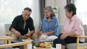 Handheld video of retired Asian friends playing rummy. The men deal the cards as everyone enjoys the game, hoping for better hands to win. They socialize in the comfort of their living room. - Powered by Shutterstock - Get 15% off with code: PIKWIZARD15