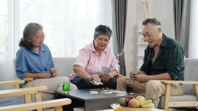 Handheld video of cheerful retired Asian friends to play rummy. The men deal the cards while everyone has fun, aiming for better hands to win. They hang out in the comfort of their cozy living room. - Powered by Shutterstock - Get 15% off with code: PIKWIZARD15