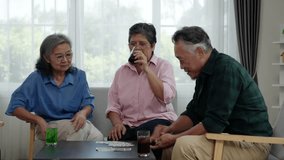 Footage of Senior Asian friends playing rummy in bright living room Men prepare to deal cards and clink glasses of friendship. Comfortable seating and large windows create an inviting atmosphere. - Powered by Shutterstock - Get 15% off with code: PIKWIZARD15