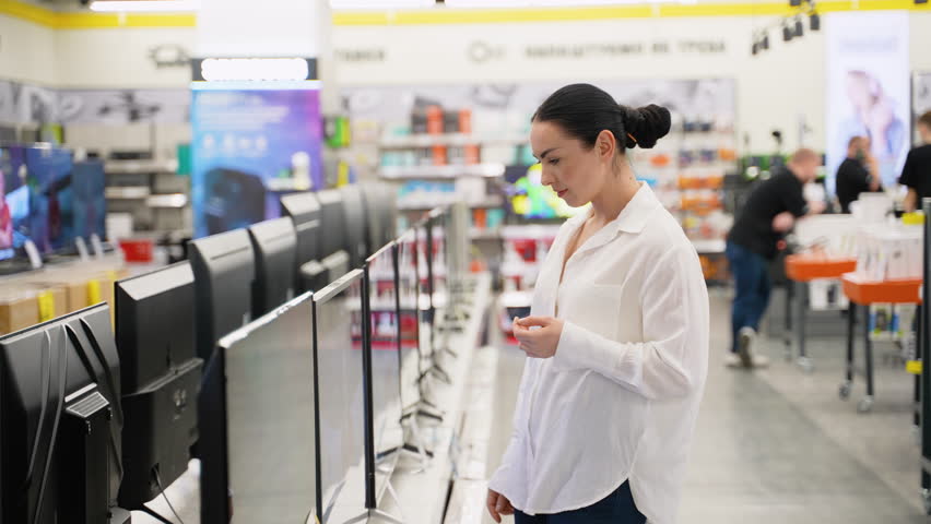 Female customer buying new tv at tech store for new home. Household appliances sale concept, black friday