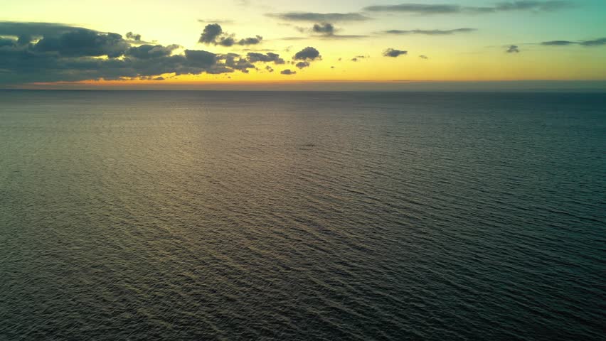 Flying over calm waters on Lake Ontario during a colourful dawn in the winter