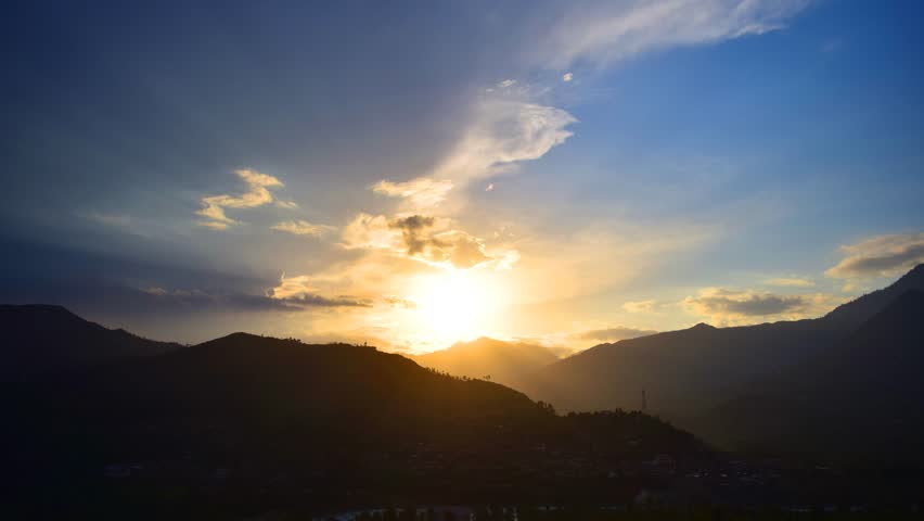 Time-lapse of a beautiful golden sunset in mountain area with golden clouds dancing in the sky 