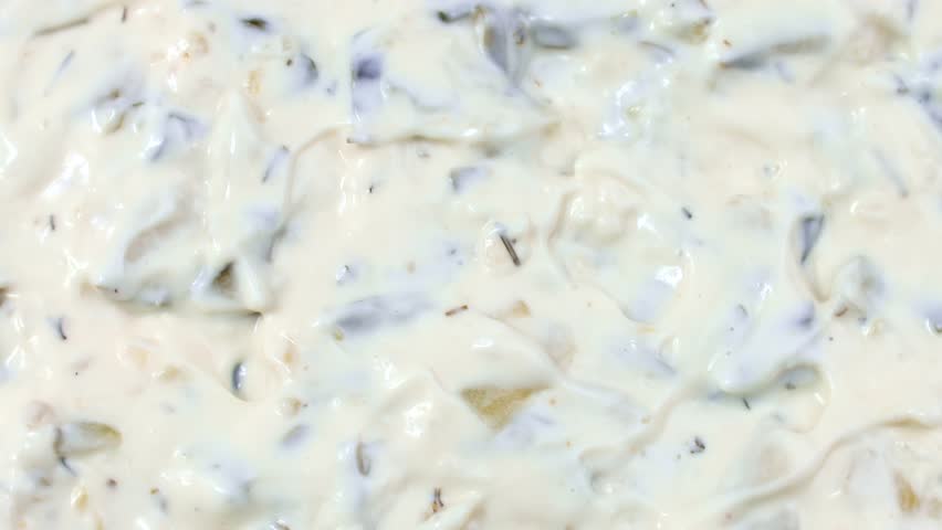 Tartar sauce with onions and pickled cucumbers circle rotation close up top view