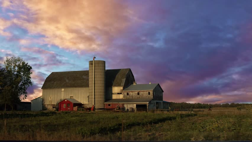 Agricultural farm at sunset with red sunset clouds
