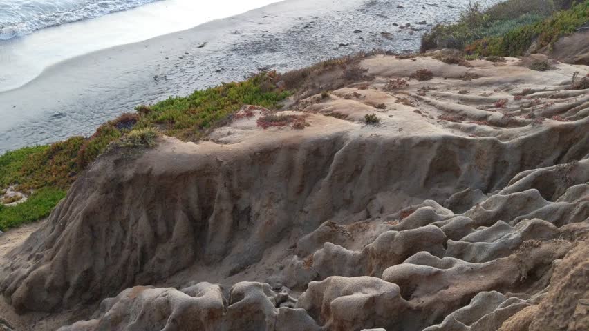 Southern California coastal views with waves and beaches, surfers and sunsets through the palm trees at Swamis Reef Surf Park in Encinitas 25 miles North of San Diego.
