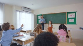 Asian young schoolgirl student dancing in front of classroom at school. Adorable little kid feeling happy and enjoy presenting learning lesson, perform a show with teacher at elementary kindergarten. - Powered by Shutterstock - Get 15% off with code: PIKWIZARD15