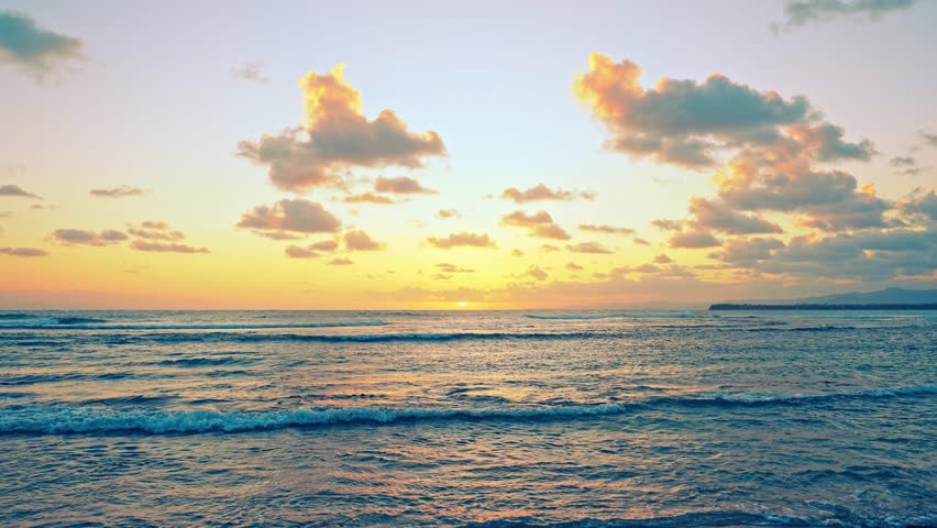 Asian sunrise over the sea on a tropical summer morning. Sea waves with a reflection of the sun
