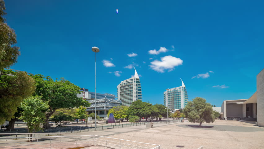Parque das Nacoes (Park of Nations) in Lisbon timelapse hyperlapse. Modern Cultural Center And a Place For a Shopping Mall, expo Pavilions Buildings and Hotels. Walking alleys with green trees