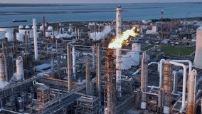 Aerial view of a chemical plant at sunset. Drone shot. Curling fire and cumin smoke filling the sky. Smoking chimneys from the factory. Chimneys of an oil refinery at sunrise pollute the environment - Powered by Shutterstock - Get 15% off with code: PIKWIZARD15