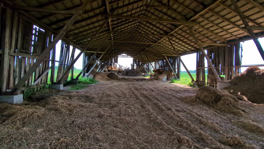Old barn with leftover of hay after winter, panoramic view