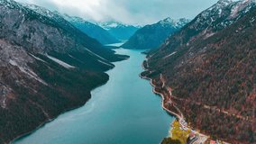 Aerial drone view Plansee lake among snow-capped mountains in Tyrolean Alps, Austria late autumn in cloudy weather. High quality 4k footage - Powered by Shutterstock - Get 15% off with code: PIKWIZARD15