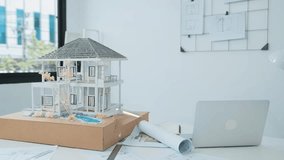 Beautiful caucasian architect focus on using tablet to check house model on meeting table with blueprint, house model and architectural document scatter around at meeting room. Immaculate. - Powered by Shutterstock - Get 15% off with code: PIKWIZARD15