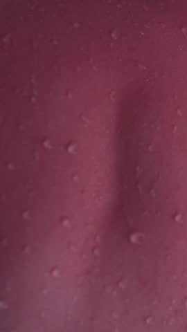 handsome young man washes himself under a cold shower in the bathroom. Drops of water flow down the skin and perfect skin of a man close up