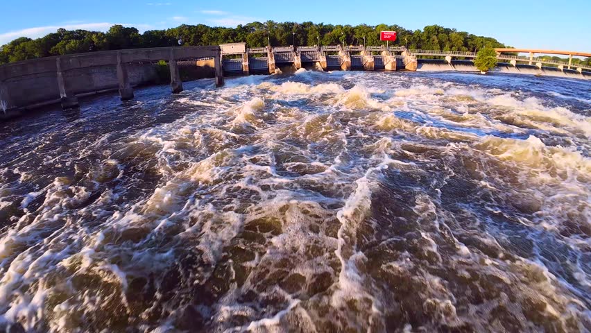 Wild exciting fast FPV drone flight just feet above rapids below the dam.
