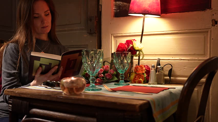 Girl in an old cafe reading a book in a romantic atmosphere