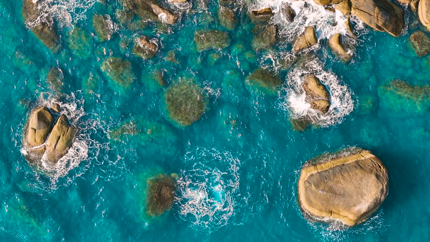 Drone aerial view over long rocky coastline. Amazing sea waves crashing on rocks seascape