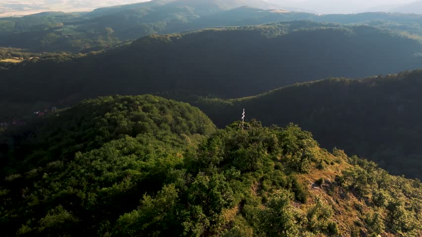 mountain valley with a cross on a hill