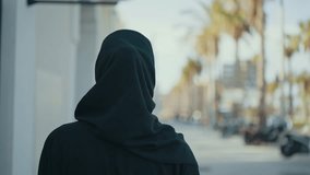 Cinematic image of a beautiful woman from Dubai wearing black abaya dress and walking in the city center and doing shopping. - Powered by Shutterstock - Get 15% off with code: PIKWIZARD15