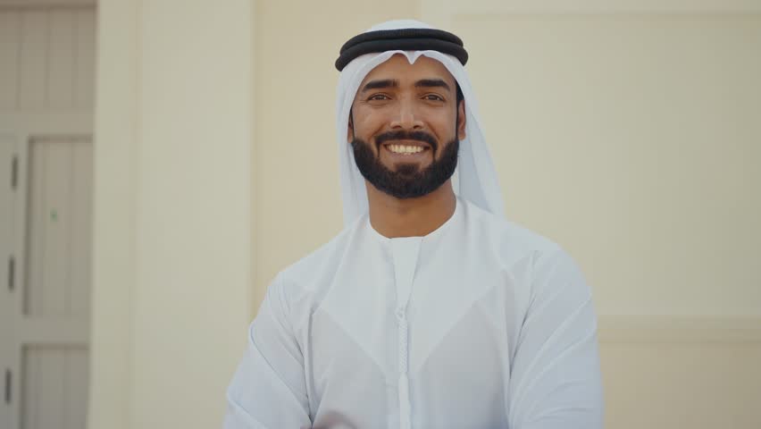 Handsome man with united arab emirates traditional kandura spending time outdoor in the city. Emirati young businessman from Dubai.
