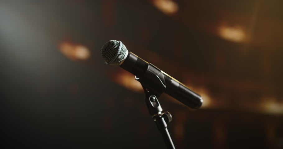 Close Up of a Microphone at a Night Concert. Music Artist Preparing to Take the Stage, Sing Popular Hit Songs to Entertain a Loving Adoring Crowd of Fans and Spectators in the Audience