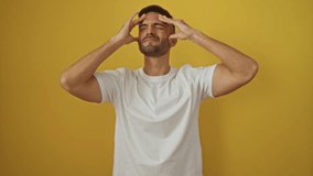 Headache suffering, young hispanic man wearing white t-shirt standing with hand on head, stress and migraine ache over isolated yellow background - Powered by Shutterstock - Get 15% off with code: PIKWIZARD15