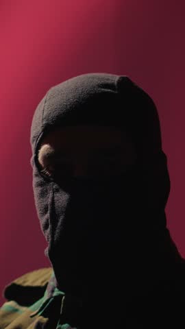 Vertical video Chinese terrorist using software algorithms on laptop to do fundamentalism propaganda on internet. CCP government secret agent wearing mask sharing dangerous illegal malware online