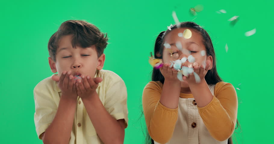 Happy children, blowing and celebration with confetti on green screen, studio or background. Portrait of excited little boy and girl with smile, glitter or sparkles for festive, party or new year