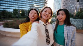 Group of only lively Chinese girls filming themselves having fun for social media together outdoors. Three generation z cheerful Asian young women using mobile phone for video dancing in city square - Powered by Shutterstock - Get 15% off with code: PIKWIZARD15
