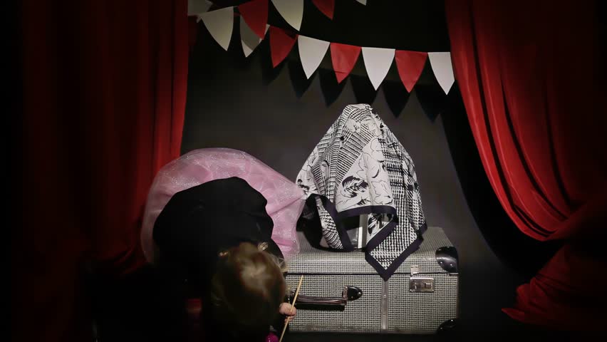 Small girl circus performer shows a trick with a hat and a rabbit in the spotlight. High quality 4k footage. High quality 4k footage