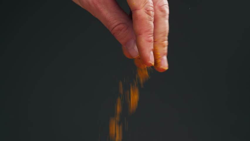 Spice turmeric powder on spoon close up. Sprinkle turmeric powder. Spice for food and drinks. Healthy