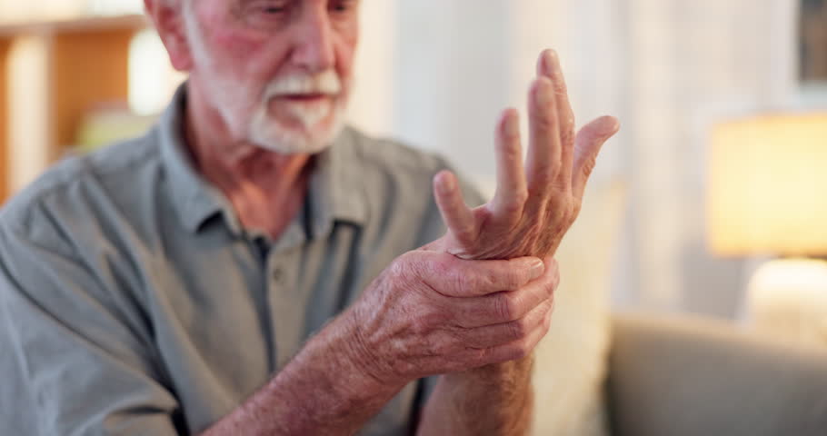 Senior man, pain and touch hand for injury with arthritis problem, inflammation and healthcare in nursing home. Elderly person, wrist massage and hurt for osteoporosis, fibromyalgia or muscle cramps