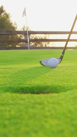 VERTICAL VIDEO. Male hand in a golf glove puts the ball on the field. Golfer placing golf ball on the tee at golf course. Close up