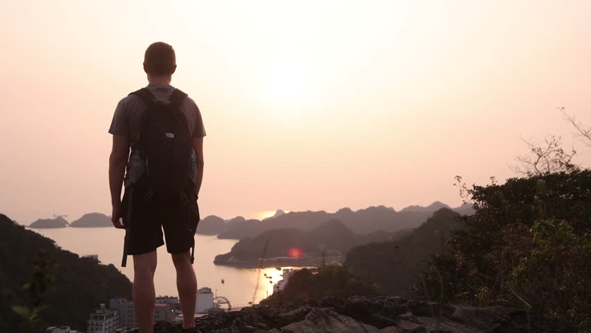 hiker overlooking epic bay at sunset in Cat Ba and Halong Bay in Northern Vietnam