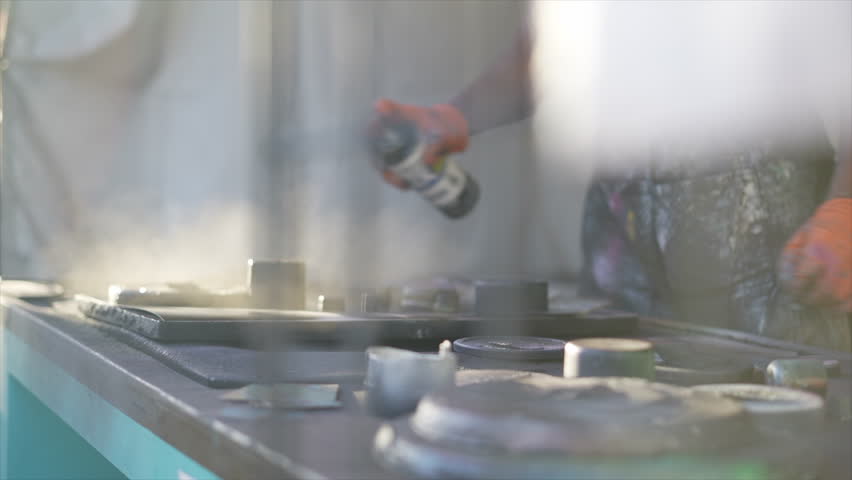 spray paint artist working on a canvas print 