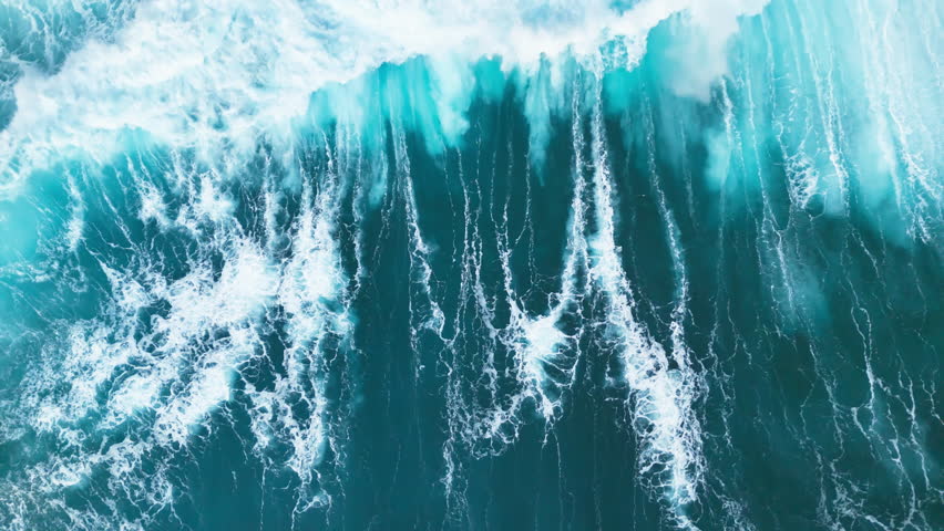 Top-down aerial view of the powerful deep blue ocean waves during the monsoon season