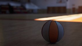 An old basketball casually sits on the ground of an empty gymnasium, awaiting the next game or practice session. - Powered by Shutterstock - Get 15% off with code: PIKWIZARD15