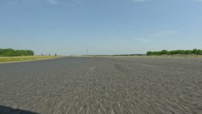 POV: Driving down the empty race circuit in the scenic countryside on a sunny summer day. High speed action shot of driving around the empty winding race track during a fun track day. Motorsport hobby - Powered by Shutterstock - Get 15% off with code: PIKWIZARD15