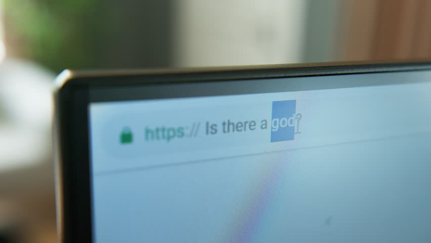 A close-up shot of a computer monitor displaying a web browser, focusing on the address bar and URL. Searching in browser ''is there a god?''