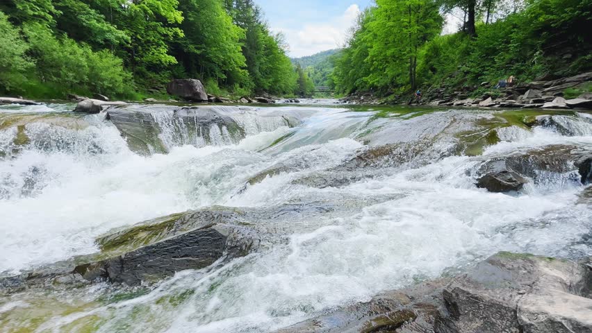 Stormy streams of water and waterfalls of a mountain river.