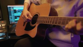 Woman playing acoustic guitar in record studio, closeup view of hands on strings . Talented and inspired female musician performing beautiful love song, professional music production and record label - Powered by Shutterstock - Get 15% off with code: PIKWIZARD15