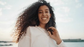 Carefree woman waving long hair, portrait against amazing cloudy sky. Happy and joyful Hispanic lady smiling broadly and enjoying life, freedom and happiness, emotional pretty girl portrait - Powered by Shutterstock - Get 15% off with code: PIKWIZARD15