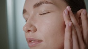 Closeup woman applying cream massaging clean face skin in morning. Peaceful beautiful model using nourishing oil. Pretty girl enjoying spa lifting routine. Natural beauty daily treatment concept. - Powered by Shutterstock - Get 15% off with code: PIKWIZARD15