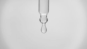 Cosmetics transparent liquid dripping from laboratory glass pipette in super slow motion. Macro shot of drop hanging down from chemical dropper. Abstract body care serum ingredients concept - Powered by Shutterstock - Get 15% off with code: PIKWIZARD15