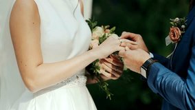 Exchange  of wedding rings Close up man puts ring on woman finger. Newlywed couple with a beautiful dress  exchanging rings on wedding ceremony. symbol of love. Marriage outdoors. valentines day celeb - Powered by Shutterstock - Get 15% off with code: PIKWIZARD15