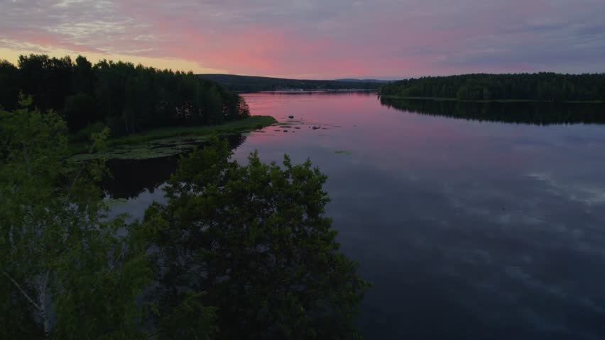 Sunset over a peaceful lake during the summer in Sweden. Shot with a drone.