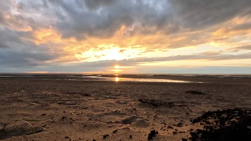Sun setting over the sea at low tide