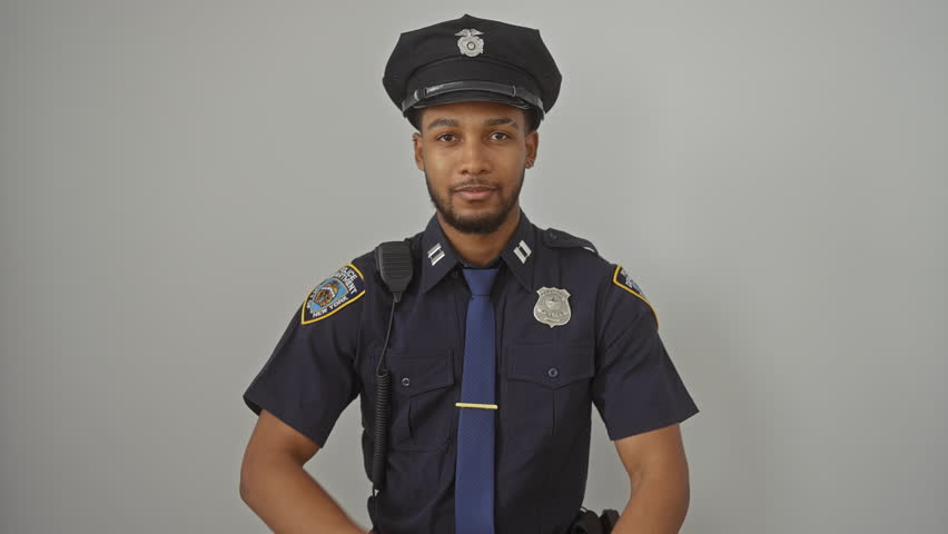 Grinning african american man donning police uniform confidently, arms crossed, front-facing. natural positivity radiating from this handsome guy over stark white isolated background.